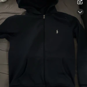 Mörkblå hoodie från Ralph Lauren - Säljer en stilren mörkblå hoodie från Ralph Lauren. Den passar som m den är stor i storleken 