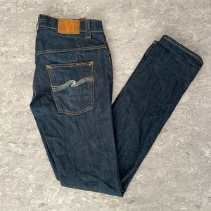 Nudie Jeans - Säljer ett par mörkblåa Nudie Jeans av modellen Thin Finn. Dessa har storlek 33/34 men passar för 31/32 på grund av modellen. Passar bra som ett vardagligt jeans plagg med en trendig look. Om det finns frågor är det bara att ställa!