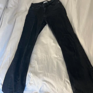Svarta jeansbyxor - Snygga svarta jeansbyxor med klassisk design. De har en rak passform och är perfekta för en stilren look. Byxorna har fickor både fram och bak samt en knapp- och dragkedjestängning.