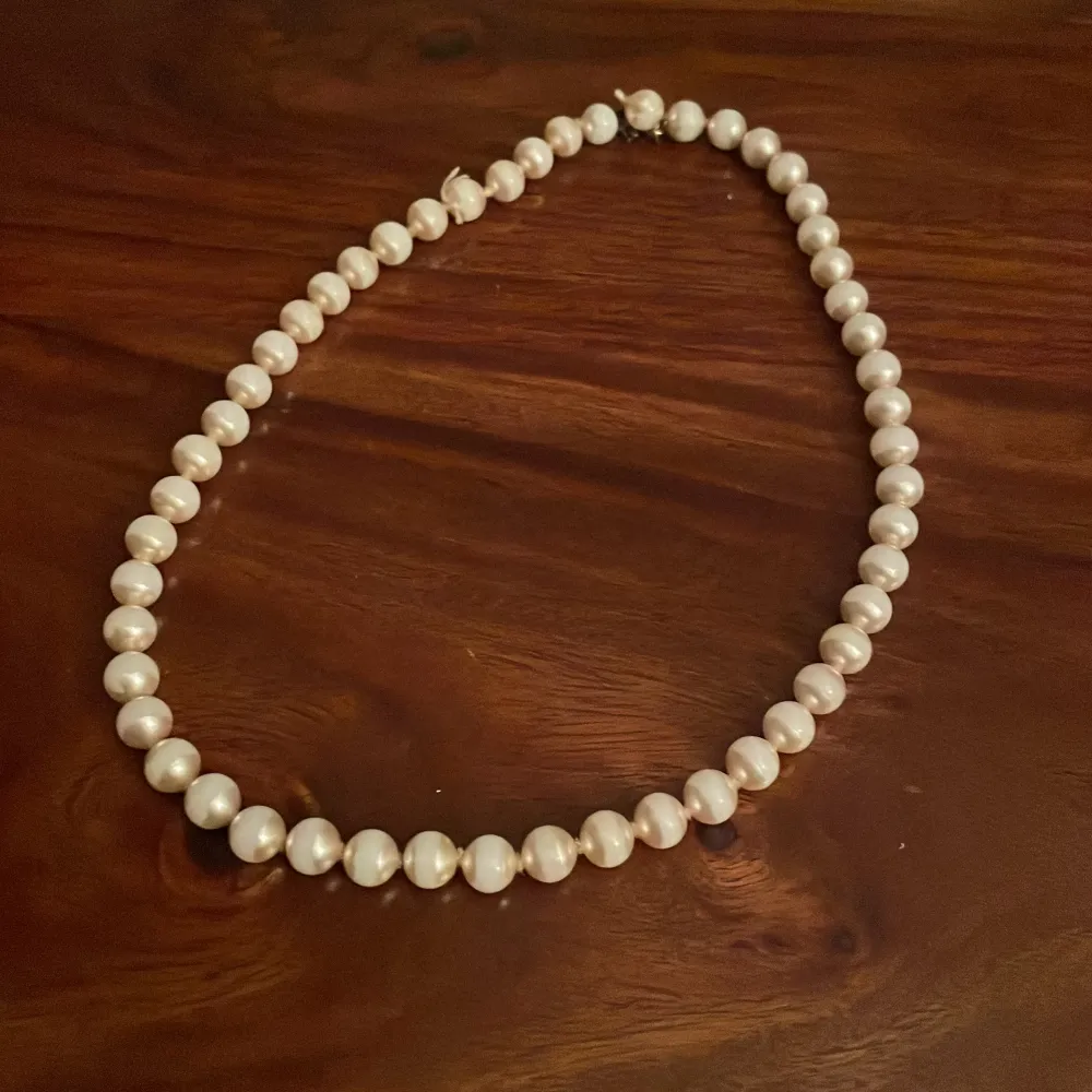 pärlhalsband med vita pärlor. Lite trasig men fixade som ni ser på bild 2. Asusteet.