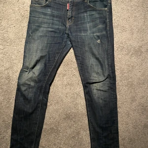 Dsquared2 jeans, 33 - Dsquared jeans i använt men väldigt fint skick. Jeansen är i storlek 33 och inte använda särskilt mycket i min ägo. De är köpta på tradera där kopior inte tillåts. Kan dock inte garantera äkhet då byxorna är begagnade. Ordernummer från tradera ges ut vid begäran. Hör av dig vid prisförslag eller vilken tanke som helst. Vi hörs!