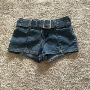Jeansshorts med bälte från H&M Divided - Snygga jeansshorts från H&M Divided i blå denim med ett matchande bälte. Tillverkade i en bomullsblandning för extra komfort. Tror inte att jag har använt den.