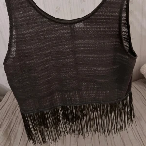 Magtröja med fransar - Snygg militärgrön magtröja med fransar längs nederkanten. Perfekt för en trendig look. Tillverkad i ett lätt och luftigt material. Sann o storleken. Använd max 2 gånger. Man ser igenom lite