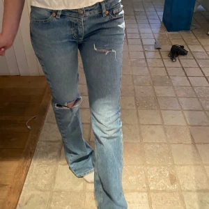 Blå bootcut jeans - Snygga blå bootcut jeans med slitningar på knäna och låg midja