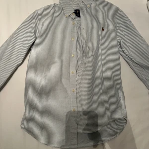 Randig skjorta från Ralph Lauren - Snygg och klassisk långärmad skjorta från Ralph Lauren. Passar en som är 155-160. Kom med förslag.