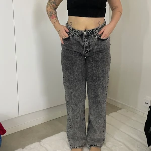 Grå jeans med hög midja - Snygga grå jeans med hög midja och en cool tvättad look. De har en straight passform och klassisk femficksdesign. Perfekta för en avslappnad stil.