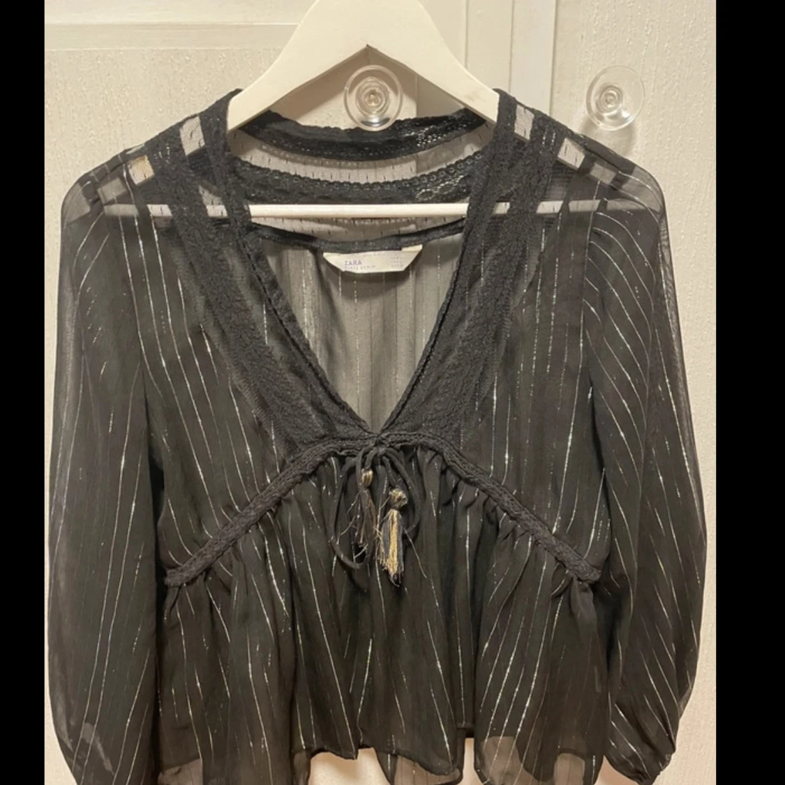 Svart blus med gulddetaljer