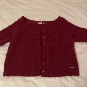 Stickad boomerang kofta - Vinröd stickad kofta från boomerang. 70% lammull. Har använts ett par gånger med är så gott som ny.