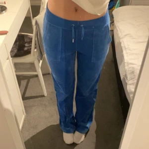 Blåa juicy couture byxor  - Säljer mina blåa juicy couture byxor i storlek S då de ej kommer till användning. Sparsamt använda, materialet som nytt men dock en liten skavank, en av de metall bitarna på snör ändan ramlat av. 