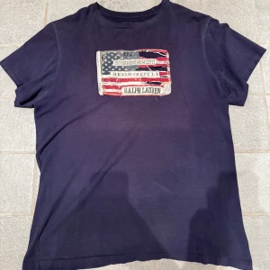 Ralph lauren t-shirt Flagga - Säljer denna schyssta Ralph lauren t-shirten med flagg trycket, den är använd men i gott skick, stor L men passar M, skriv vid funderingar!