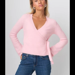 Rosa omlottopp från ginatricot - Säljer den här söta toppen från ginattricot som är slutsåld! omlottopp med knytning i midjan. Toppen har en v-ringad design och långa ärmar.