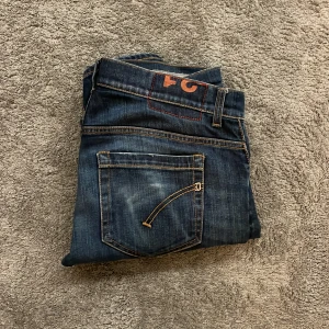 Mörkblå jeans från Dondup - Feta mörkblå jeans med knappgylf och klassisk femficksdesign. Perfekta för en stilren look.