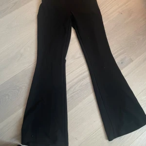 Svarta byxor från Gina Tricot - Snygga svarta byxor från Gina Tricot med en bootcut-stil. Perfekta för en stilren look och kan matchas med olika toppar för en trendig outfit.