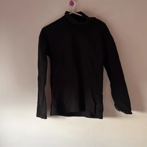 Svart polotröja i fleece  - Snygg och enkel svart polotröja med långa ärmar. Perfekt för kyligare dagar och lätt att matcha med olika outfits.