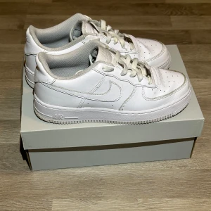 Vita Nike Air Force sneakers - Snygga och klassiska vita Nike Air Force sneakers. Perfekta för en stilren look. Skorna är använda och har lite crease på tå boxen. Sko lådan för air force 1 följer med. Priset är inte hugget i sten. Vid fler frågor kontakta mig 