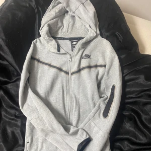 Nike Tech Fleece - Säljer en Nike Tech Fleece i jätte bra skick , utan skador eller defekter, använd ungefär 5 gånger och är nästan som ny. Passar till både killar & tjejer, storleken är XL i barn storlek och det motsvarar S-M i hoodies. 