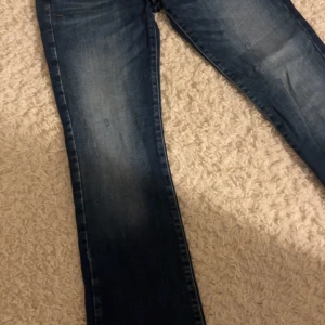 Blå jeans med bootcut - Snygga blåa bootcut jeans med coola ”slitnings” detaljer från LTB❣️❣️❣️ I jättefint skick! Strl 27/30, säljer för att de har blivit för korta.