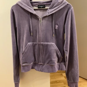 Lila juicy couture sett - Jättefint lila sett från juicy coutur . Det är i använt skick då jag har haft det i 2 år, sömen har gått upp lite i skrevet finns bild i slutet                                 Storlek: hoodie M  byxor L                                    Pris: 700 + frakt