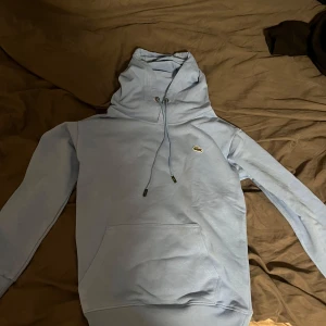 Blå Lacoste tröja  - Min tröja är helt ny, storlek S men känns som xs och det är därför jag säljer! 