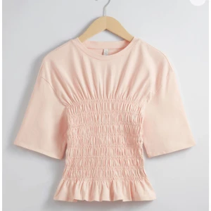 Ljusrosa topp med smockdetaljer - Säljer denna populära smockade topp från other stories som är helt slutsåld! Tröjan har inga defekter och är i bra skick, skriv privat för frågor eller mer bilder!💕