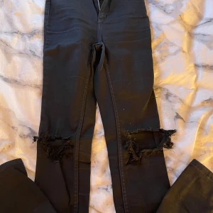 Svarta jeans  - Svarta jeans med håll på knäna, 