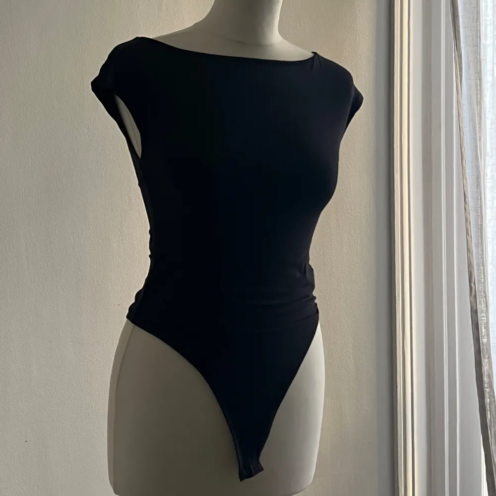 Säljer en svart bodysuit från Zara i storlek XS. Den är ärmlös och har en tight passform som framhäver figuren. Perfekt för både vardag och fest!. Toppar.