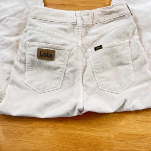 Beige manchesterbyxor från Lois - Säljer ett par snygga beige manchesterbyxor från Lois. Byxorna är mid waist och en straight passform. De är tillverkade i mjukt manchestertyg och har klassiska fem fickor samt en dragkedja och knapp framtill. nypris ca 2000 kr