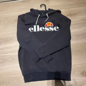Mörkblå Ellesse hoodie  - Hoodien är använd men i bra skick, lite tvätt påverkad.  Stl: S. Pris kan diskuteras! 