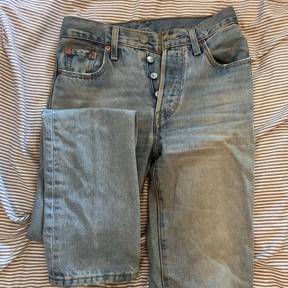 Säljer ett par ljusblå jeans från Levi's. De är i bra skick och har en klassisk design med fem fickor och knappar i gylfen. Perfekta för en avslappnad vardagslook. (köpta för 1300). Jeans & Byxor.