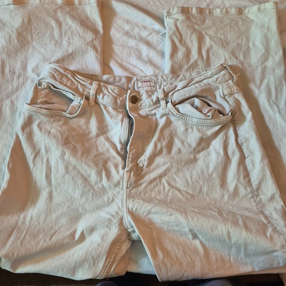 Säljer ett par snygga beige jeans från Pepe Jeans. De är i storlek L och har en klassisk design med fem fickor och en dragkedja framtill. Jeansen är tillverkade i bomull och har en normal passform. Perfekta för både vardag och fest!. Jeans & Byxor.