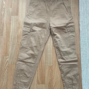 Beige cargobyxor med fickor - Säljer ett par beigea cargobyxor i riktigt bra skick, lappen är avklippt satt ja vet inte vad det e för storlek men skulle uppskatta att de va storlek S🤗