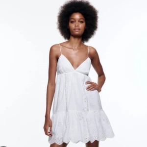 Vit sommarklänning med broderi - Säljer en superfin vit klänning perfekt för sommaren! Den är ärmlös med smala axelband och har en v-ringad design. Klänningen är dekorerad med vackra broderier. Perfek för att använda med en tröja över eller bara som den är😊😊