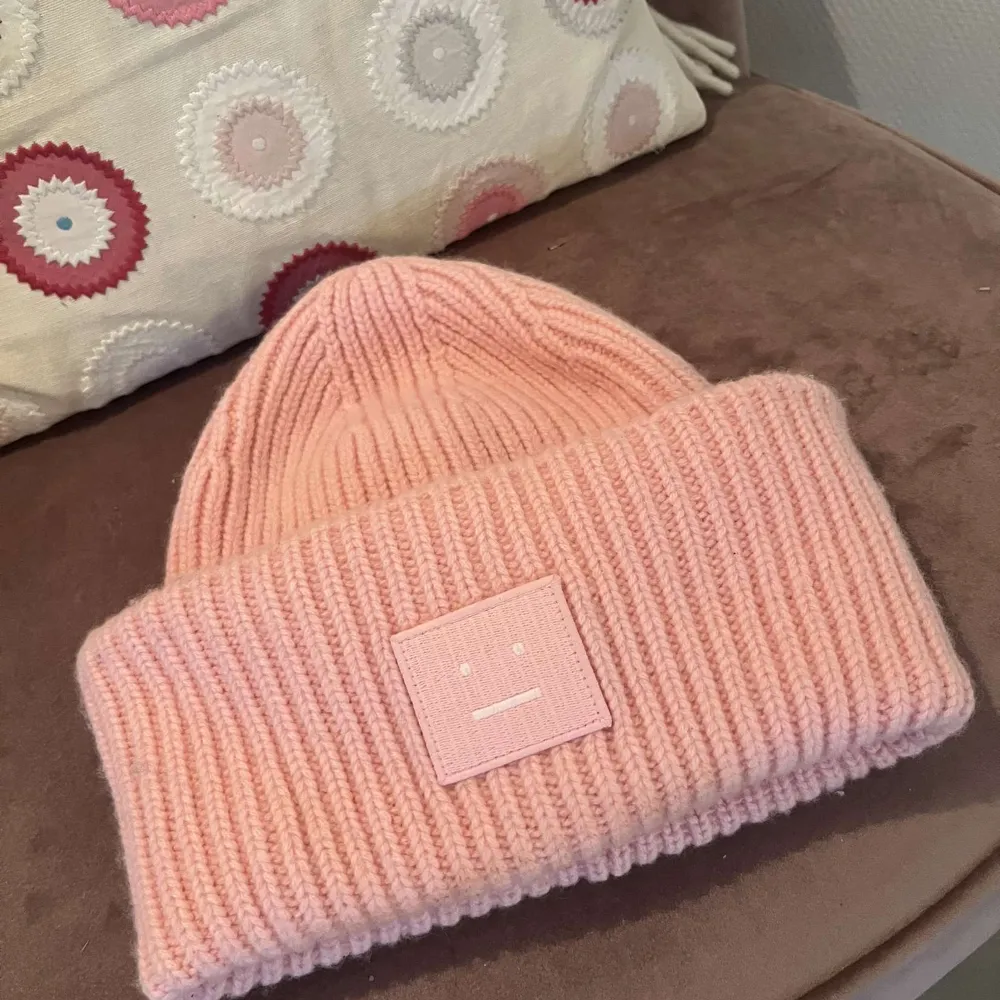 Superfin rosa stickad mössa från Acne Studios. Knappt använd, utan några defekter. Perfekt för att hålla sig varm och snygg under kyliga dagar. Den ribbade designen ger en skön passform och den mjuka färgen är lätt att matcha med olika outfits. Vid fler fråger är det bara att skriva till mig!🌸. Accessoarer.