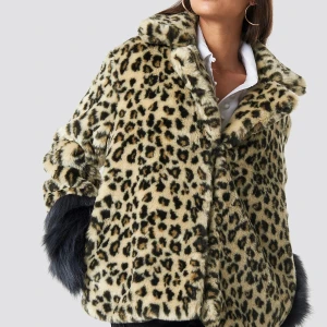 Leopardmönstrad pälsjacka - Säljer en supercool leopardmönstrad pälsjacka med fluffiga svarta detaljer vid ärmsluten. Perfekt för att sticka ut på festen eller hålla sig varm under hösten. Jackan har en avslappnad passform och är riktigt mjuk och skön. Ett måste för garderoben om du älskar djurmönster!