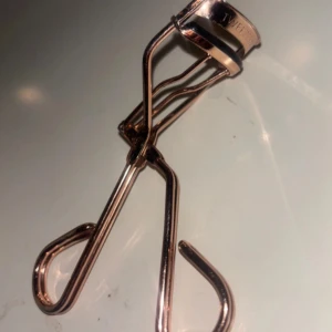 Ögonfransböjare i roséguld - Snygg och elegant ögonfransböjare i roséguld från Tweezerman. Perfekt för att få till den där extra böjen på fransarna. Den har en bekväm design som gör den enkel att använda. Ett måste i sminkväskan för att få till den perfekta looken!