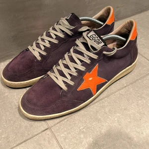 Golden Goose Ballstar - Tja! Säljer dessa sjyssta lila Golden Goose ballstars. Skorna är i fint skick men har lite heeldrag men inget man ser, meningen med skon är att den ser lite använd ut. Storlek 42 men passar även för 43, dust bag ingår men ingen låda därav pris. Hör av vid frågor!