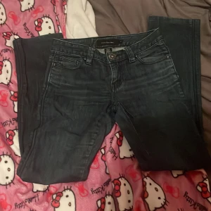 Mörkblå jeans från Calvin Klein - Säljer ett par snygga mörkblå jeans från Calvin Klein i storlek s. De har en klassisk femficksdesign med dragkedjor på bakfickorna och en knapp med logga framtill. Perfekta för både vardag och fest! 🖤