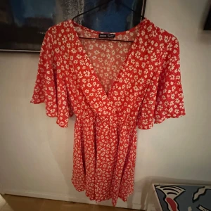 Röd klänning - Röd klänning med vita detaljer. Klänningen är i nyskick! Storlek S