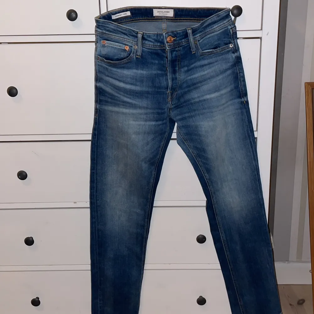 Säljer ett par snygga blå jeans från Jack & Jones i modellen Comfort/Mike. De har en klassisk femficksdesign och en bekväm passform. Perfekta för både vardag och fest! 🕺. Jeans & Byxor.