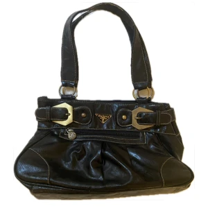 Svart axelväska! - Snygg svart axelväska i skinn från Baluna. Väskan har fina spännen och en litet fack framtill. Perfekt skick och bra kvalitet på materialet! väskan har ett stort fack och flera mindre inuti. 22x 33 cm 🩷🩷