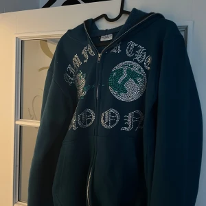 Aim for the moon rhine stone hoodie - Säljer min rhinestone hoodie från märket Aim for the Moon. Endast använd ett fåtal gånger och är i storlek M. Hoodien är i väldigt bra skick och håller hög kvalitet. Perfekt för dig som söker ett unikt och stilrent plagg!