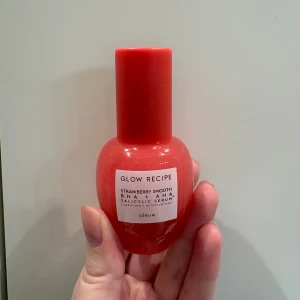 Glow Recipe Strawberry Smooth BHA + AHA Salicylic Serum - Säljer ett Glow Recipe Strawberry Smooth BHA + AHA Salicylic Serum. Den kommer i en söt, jordgubbsröd flaska som är både snygg och praktisk. Perfekt för att få en jämn och strålande hy. Används för att exfoliera och förfina hudens textur. Finns 70% kvar av produkten! 