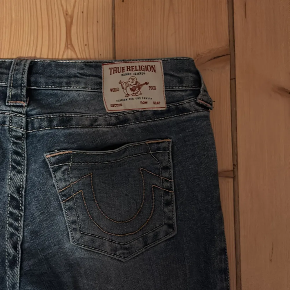 Säljer ett par snygga blå jeans från True Religion i storlek 27. De är uppsydda så passar mig som e 150 cm. Inga defekter, ultra low-waist.De har en bootcut-stil. Perfekta för både vardag och fest! 🕺nypris 1399. Farkut & Housut.
