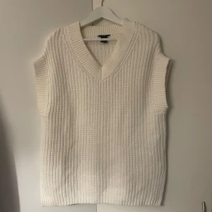 Vit stickad väst från Lindex - Säljer en superfin vit stickad väst från Lindex i storlek S. Den har en snygg v-ringad design och är perfekt under hösten. Västen är i mycket bra skick och passar till både vardag och fest. Perfekt för att hålla sig varm och stilren! 🤍