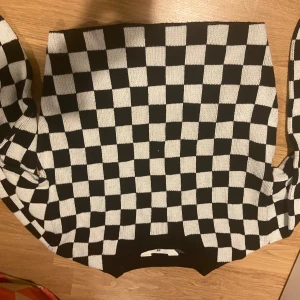 Svartvit rutig tröja från H&M - Säljer en cool svartvit rutig tröja från H&M. Perfekt för att sticka ut med sitt schackrutiga mönster. Tröjan är i bra skick och passar perfekt för både vardag och fest. Den är bekväm och stilren, ett måste i garderoben!