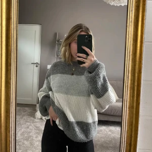 Randig stickad tröja i grå och vit - Är 165 och den sitter lite ozersized på mig. Mycket bra skick. Den är storlek xxs på lappen men sitter som Medium. Mysig och oversized stickad tröja med breda ränder i olika nyanser av grått och vitt. Perfekt för kyliga höst- och vinterdagar. Tröjan har långa ärmar och en avslappnad passform som gör den superbekväm att bära. Perfekt för en casual look eller att mysa i hemma.