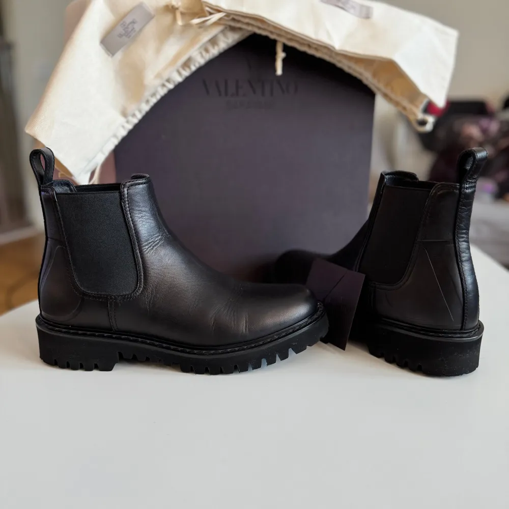 Säljer ett par snygga svarta Chelsea boots från Valentino i skinn. De är i nytt skick och kommer med originalförpackning. Perfekta för höst och vinter med en robust sula som ger bra grepp. Stilrena och tidlösa, passar både till vardags och fest. Påse till dem ingår 1, kvitto finns allt finns, ordinarie pris 11900kr, mitt pris 5500kr. Skor.