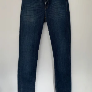 Mörkblå jeans från Selected Femme - Säljer ett par snygga mörkblå jeans från Selected Femme i modellen Sfelena Mid Rise. De är ej använda och i ny skick och har en klassisk design med fem fickor och knappgylf. Perfekta för både vardag och fest!