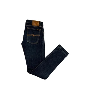 Nudie Jeans - Nudie jeans i en snygg mörkblå färg. Modellen heter tight long John. Storlek 29/32. Sköna slitningar som ger karaktär! Bra skick!