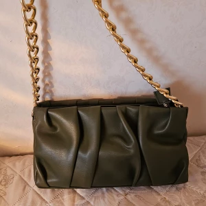 Axelväska från MQ  - Snygg MQ väska som passar på vardagen eller kväll. Köpt för 499 kr och använt enstaka gånger. Väskan är som ny och är i väldigt god skick!   Material: 100% polyuretane Foder: 100% polyester Tvättråd: Tvättas ej Mått: Höjd: 15cm, bredd: 26cm, djup: 6c